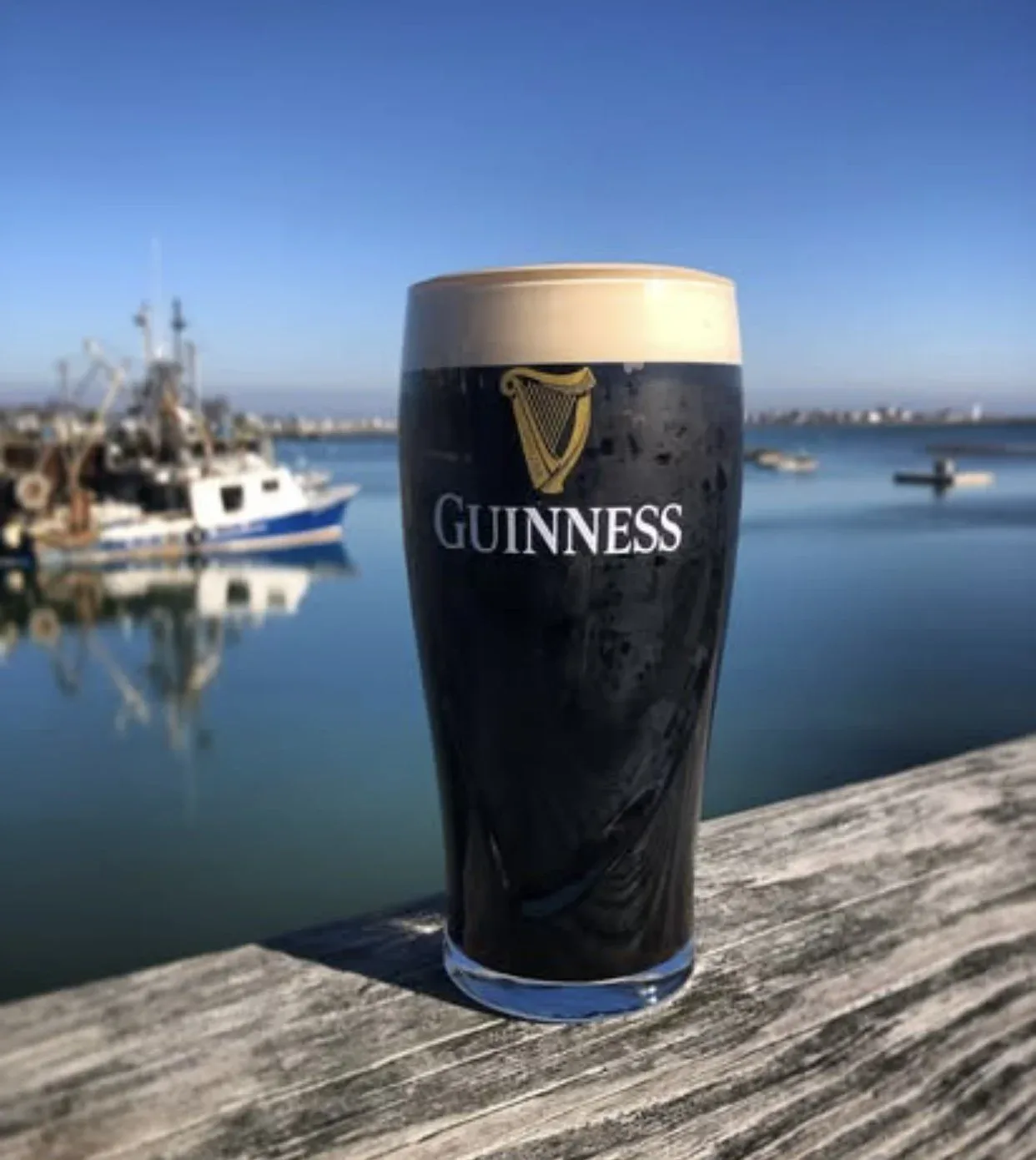 Guinness pint with Scituate Harbor fishing boats in background